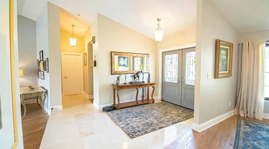 Bright foyer with decorative doors and table.