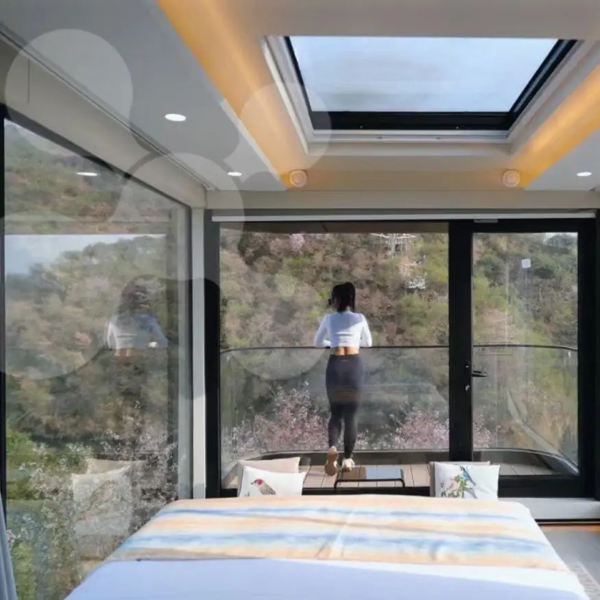 Woman enjoying mountain view from modern bedroom.